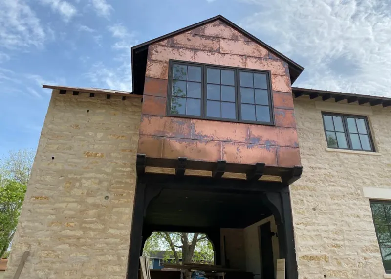 Copper metal panel facade on a stone building for Roof Repair in Essex Junction